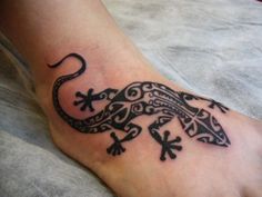 a lizard tattoo on the foot of a person's foot with an intricate design