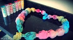 a bracelet made out of yarn and crepe paper on a counter next to some spray paint