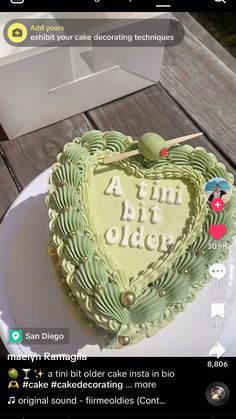 a heart shaped cake sitting on top of a white plate next to a box with the words atm art older