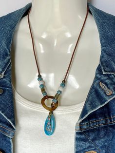 Simple but eye-catching lariat necklace with a brilliant 1 1/2" Blue Lace Agate pendant and a 1" ring of Mother of Pearl for closing, along with blue patina Bronze beads and a blue patina charm to add more color. All on 2mm distressed brown leather cord. To wear place open necklace around neck, then put pendant thru ring, and adjust to your liking. No lead or nickel used. Please use the Last On, First Off approach. Stones discolor with lotions, perfumes, hairspray, sweat, chlorine, even some soaps, and will break if dropped. Beach Lariat Jewelry With Adjustable Length, Beach Jewelry Lariat With Adjustable Length, Bohemian Lariat Drop Necklace Gift, Bohemian Teardrop Jewelry With Adjustable Chain, Bohemian Jewelry With Adjustable Teardrop Chain, Adjustable Teardrop Lariat Necklace, Bohemian Adjustable Lariat Drop Necklace, Adjustable Bohemian Lariat Drop Necklace, Adjustable Spiritual Lariat Jewelry