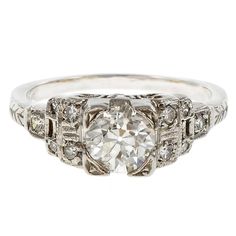 an antique style diamond ring with filigrees on the shoulders and sidestones