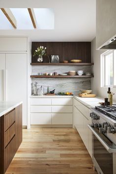 a kitchen with wooden shelves and white counter tops, along with wood flooring that matches the ceiling