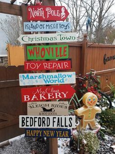 a wooden pole with many different signs on it's side in front of a fence