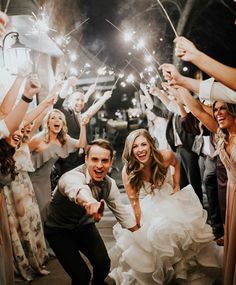 a bride and groom are surrounded by sparklers