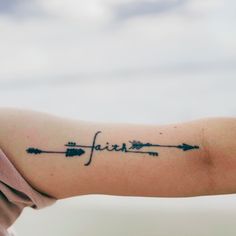 a woman's arm with an arrow and the word faith tattooed on her left arm