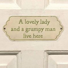 a white door with a sign that says a lovely lady and a grumpy man live here