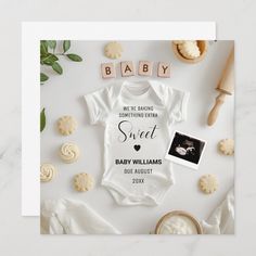 a baby announcement card with cookies and cookies on it, including an infant's bodysuit