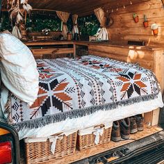 a bed in the back of a truck with a quilt on it's side