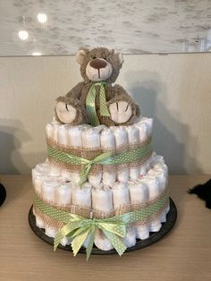 a teddy bear sitting on top of a diaper cake