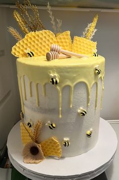 a yellow and white cake with honey combs on it's side, dripping icing