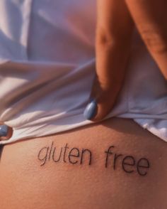 a woman's stomach with the word gluten free written on it, in front of her belly