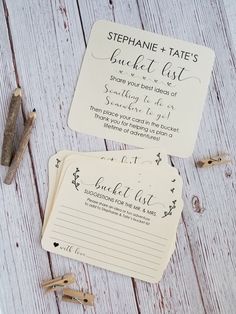 two wedding stationery cards on top of each other next to a pen and paper clip