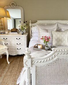 a white bed sitting in a bedroom next to a dresser