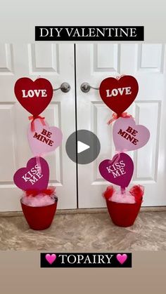 two valentine's day decorations in buckets with hearts hanging from the front door