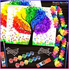 an art project with paint, flowers and trees on the table next to it is a rainbow tree