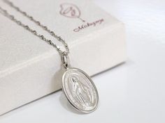 Medium size Miraculous Medal, Sterling silver Our Lady of Grace pendant, Miraculous Medal charm, Detailed Miraculous Medal from Medjugorje This beautiful Miraculous Medal is made with coin technology which makes medal very precise and rich with details. Edge of medal is diamond cut so it gives it very nice shiny look in meanwhile centerpiece is satiated to ensure high fine details come more to expression. Each medal is rhodium plated so it doesn't tarnish or change color. Size of medal is 20 x 1 White Gold Necklace With Miraculous Medal For Gift, White Gold Necklace With Miraculous Medal As Gift, Silver Necklace With Miraculous Medal For Gift, Commemorative Silver Jewelry With Miraculous Medal, Silver Jewelry With Miraculous Medal For Gift, Silver Necklace With Miraculous Medal As Gift, Silver Miraculous Medal Memorial Jewelry, Silver Miraculous Medal Necklace For Commemoration, Silver Miraculous Medal Jewelry As Gift