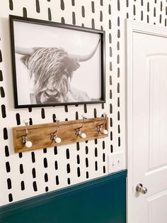 a black and white photo hangs on the wall next to a coat rack with hooks