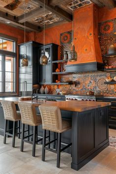 an orange and black kitchen with lots of counter space in the center, along with four bar stools