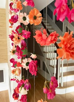 colorful flowers hanging from the ceiling next to stairs