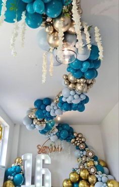 blue and gold balloons are hanging from the ceiling