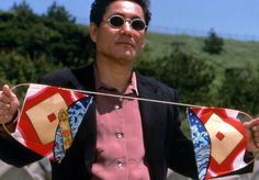 a man in sunglasses holding up a kite