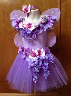 a dress made out of purple tulle and flowers