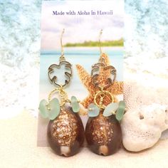 "Hawaiian Jewelry, Handmade Jewelry, Sea Shell Jewelry, Hawaii Jewelry, Shell Jewelry, Shell Earrings, Beach Jewelry, Beach Earrings, Seashell Jewelry, Seashell Earrings, Bridesmaid Beach Wedding, Bridal Gifts, Gifts from Hawaii, Handmade in Hawaii, ♥ Item Details ♥ Size/length: About 3\" in length ♥ Details: Pretty delicate gold plated Monstera leaf earrings adorned with Cowrie shell and tiny wire-wrapped seafoam green beach glass beads. Pretty tropical combination. Perfect to wear every day to Cowrie Shell Earrings, Monstera Leaf Earrings, Tropical Earrings, Hawaii Jewelry, Earrings Beach, Green Beach, Seashell Earrings, Hawaiian Jewelry, Beach Earrings