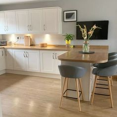 the kitchen is clean and ready to be used for cooking or eating, with two bar stools in front of the island