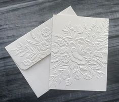 two white cards with floral designs on them