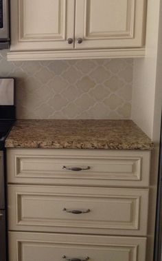 a kitchen with white cabinets and granite counter tops