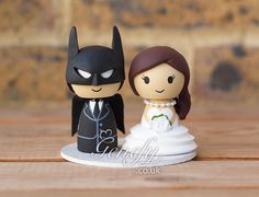 a bride and groom figurine on a wooden table