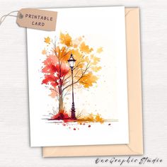 a card with an image of a tree and a lamp post in the fall colors