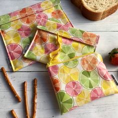 fruit print lunch bags with pretzels, strawberries and oranges next to them