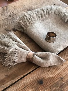 a napkin with a ring on it sitting on top of a wooden table next to a cup