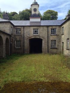 an old building with a clock tower on the top of it's roof and windows