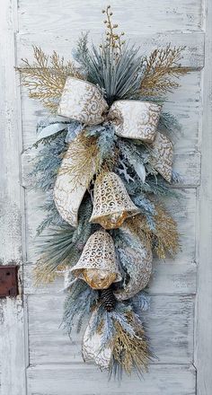 a christmas wreath hanging on the side of a white door with gold and silver decorations