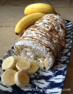 a banana and powdered sugar roll on a plate with sliced bananas