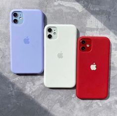 three different colored iphone cases sitting next to each other on top of a cement surface