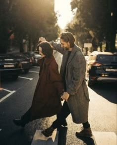 a man and woman walking across a cross walk