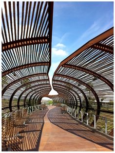 the walkway is lined with wooden slats and metal railings, as well as blue sky