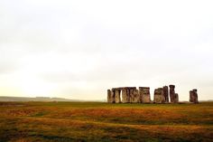 the stonehenge monument stands in an open field