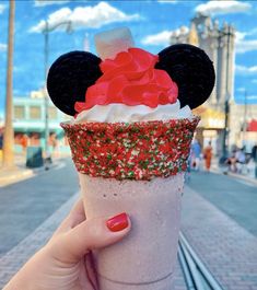 a person holding up a drink with minnie mouse ears on it