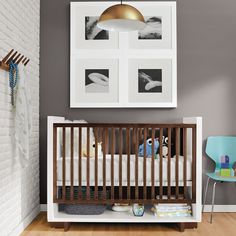 a baby's room with a crib and pictures on the wall