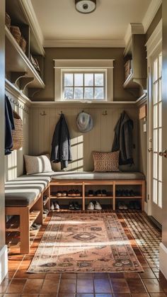 a mud room filled with lots of coats and shoes