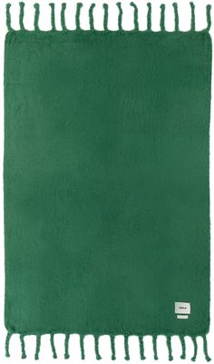 a green rug with tassels on it