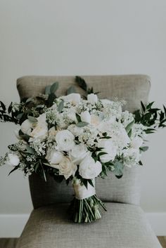 a bouquet of white flowers sitting on top of a chair