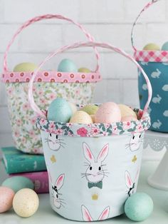 three baskets filled with easter eggs sitting on top of a table next to other items