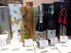 several bottles of wine are on display in front of boxes with chinese writing and symbols