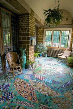 an outdoor room with colorful tiles on the floor