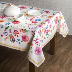 a table with a white plate and bowl on it next to a brick wall in a room